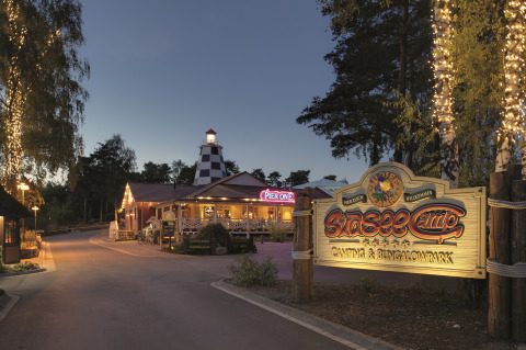 Entrance of Südsee-Camp camping and bungalow park at dusk with twinkling lights and welcoming signs.