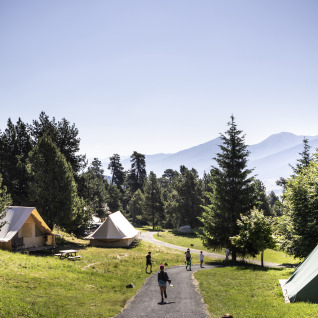 Glamping-Unterkünfte im Huttopia Font-Romeu, Languedoc-Roussillon, umgeben von Bergen und Wald.
