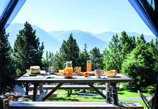 Vue depuis une tente de glamping sur une table de petit-déjeuner à Huttopia Font-Romeu, Languedoc-Roussillon.