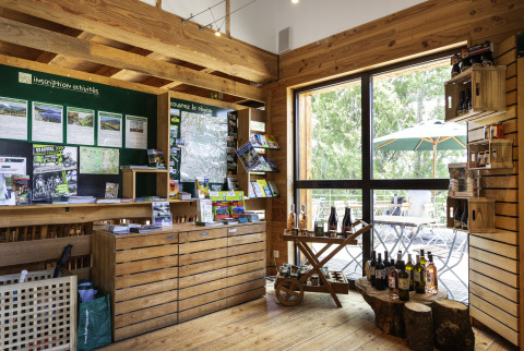 Indvendigt informationscenter på Huttopia Font-Romeu - Glamping Languedoc-Roussillon med brochurer og vin.