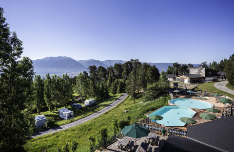 Vista de Huttopia Font-Romeu Glamping en Languedoc-Roussillon con piscinas, autocaravanas y paisaje montañoso.