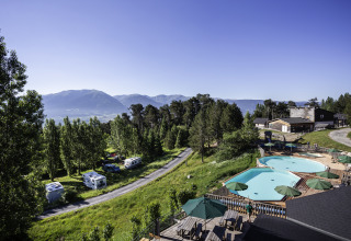 Blick auf Huttopia Font-Romeu Glamping in Languedoc-Roussillon mit Pools, Wohnmobilen und Bergen.