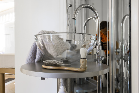 Modernes Glamping-Badezimmer mit Glaswaschbecken, Bürste und Rasierpinsel im Vallicella Glamping Resort Toskana.