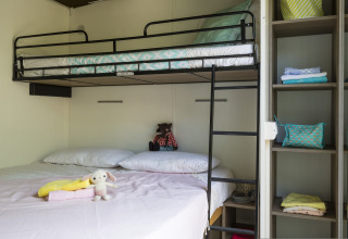 Cottage de glamping familial avec lits superposés et étagères au Vallicella Glamping Resort en Toscane.