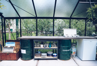 Buitenkeuken bij REBL Outdoor – Bell tenten Friesland met gasstel, servies en koelkastje.