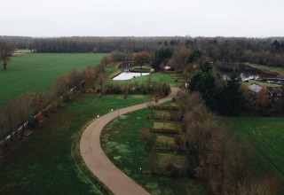 Luchtfoto van REBL Outdoor – Bell tenten Friesland glamping, gelegen tussen groene velden en een vijver.