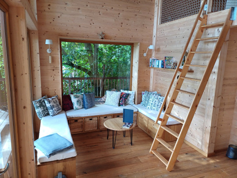 Intérieur de la cabane Sankt Martin en Rhénanie-Palatinat avec murs en bois et banquette confortable.