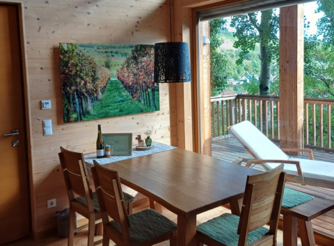 Essbereich mit Holzmöbeln und Balkon in der Glamping-Unterkunft Sankt Martin Baumhaus, Rheinland-Pfalz.