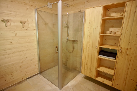 Modernes Bad mit Holzwänden, Dusche und Schrank im Glamping Sankt Martin boomhut in Rheinland-Pfalz.