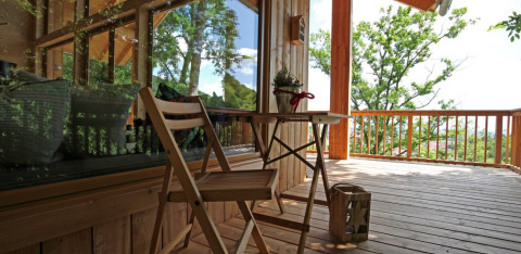 Treehouse accommodation with wooden terrace, table and chairs at Sankt Martin Glamping, Rhine-Palatinate.