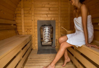 Donna che si rilassa in una sauna di legno a Natuurcamping Lassan - Wijnvaten Mecklenburg-Vorpommern, Germania.