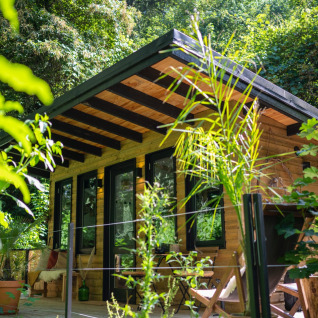 Glamping accommodatie van hout bij Land of Deveza - Glamping Portugal, omgeven door groene natuur.