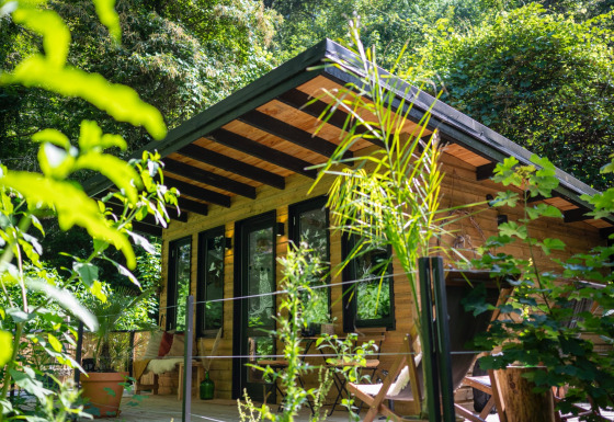 Charming wooden glamping cabin at Land of Deveza - Glamping Portugal, nestled in lush green forest.