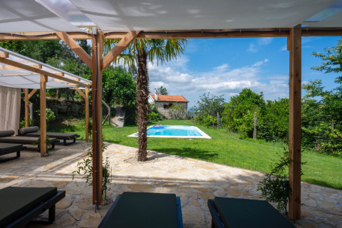 Terrace view with loungers, pool, and lush greenery at Land of Deveza Glamping Portugal on a sunny day.