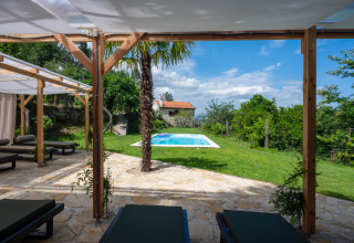 Vista de terraza con tumbonas, piscina y vegetación en Land of Deveza Glamping Portugal durante un día soleado.