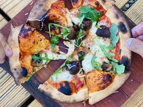 Pizza cotta a legna con funghi e rucola al Land of Deveza - Glamping Portugal, esperienza all'aperto.