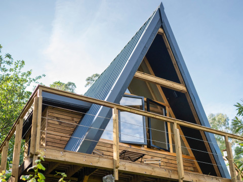 Land of Deveza - Glamping Portugal : Cabane en bois moderne de style A-frame avec terrasse, idéale pour le glamping.