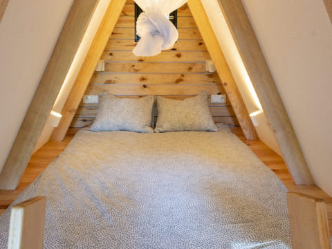 Knusse glamping-accommodatie met bed in een A-frame hut bij Land of Deveza - Glamping Portugal.