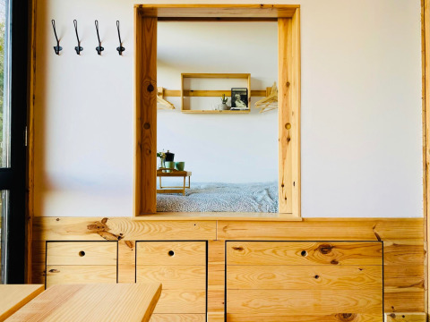 Indvendig udsigt af Land of Deveza - Glamping Portugal med træmøbler og hyggeligt soveområde.