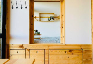 Interieur van Land of Deveza - Glamping Portugal met houten meubels en een knusse slaapkamer in beeld.