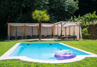 Zona glamping en Land of Deveza - Glamping Portugal con piscina, palmera y tumbonas al aire libre.