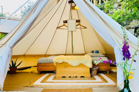 Indvendig udsigt af et luksuriøst glamping-telt med hyggelige senge og dekoration på Land of Deveza i Portugal.
