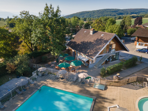 Vista aerea di Huttopia Divonne Les Bains glamping in Rhône-Alpes con piscina e zona relax all'aperto.