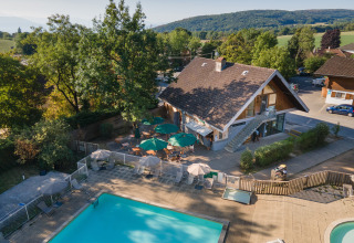 Luftaufnahme von Huttopia Divonne Les Bains Glamping im Rhône-Alpes mit Pool und Sitzbereich im Freien.