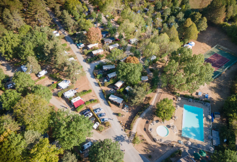 Luchtfoto van glamping Huttopia Divonne Les Bains in Rhône-Alpes met zwembad en kampeerplekken.