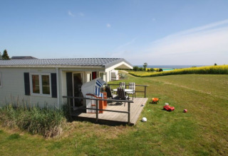 Glamping-Lodge bei Camping Walkyria mit Terrasse, Blick auf die Ostsee und Spielzeug im Garten.