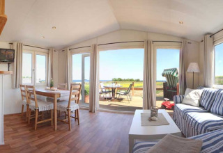 Heldere glampinglodge bij Camping Walkyria met keuken, eethoek en uitzicht op de Oostzee vanaf het terras.