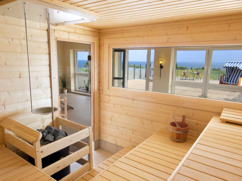 Sauna moderne en bois aux Camping Walkyria Lodges avec vue sur la mer Baltique à travers de grandes fenêtres.