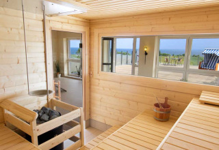 Helle Sauna aus Holz bei Camping Walkyria Lodges an der Ostsee mit Blick aufs Meer.