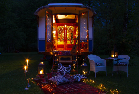 Alojamiento glamping en Park am See, Obertraun, Austria, con luces, linternas y cojines acogedores afuera.