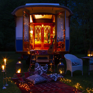 Glampingverblijf Park am See in Obertraun, Oostenrijk, met feeërieke kussens, lantaarns en lichtjes.