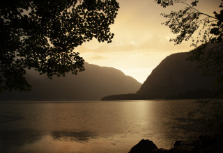 Zonsondergang over meer en bergen bij Park am See, glamping accommodatie in Obertraun, Oostenrijk.