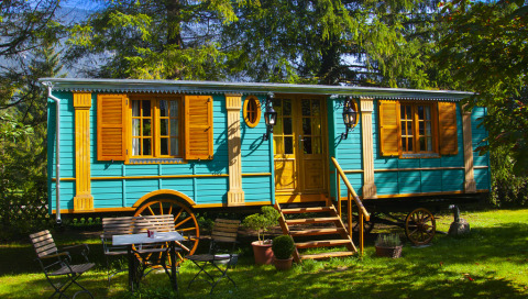 Bunte Zigeunerwagen-Unterkunft zum Glamping im Park am See, Obertraun, Österreich, im grünen Garten.