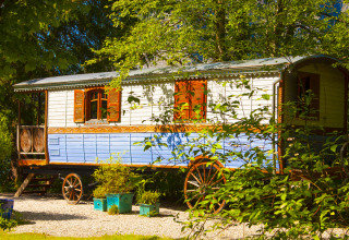 Glamping-Unterkunft im Park am See in Obertraun, Österreich: Bunte Wagenidylle im Grünen.