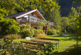 Alojamiento glamping Park am See en Obertraun, Austria, rodeado de jardines verdes y naturaleza exuberante.