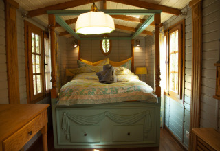 Accogliente camera glamping con letto a baldacchino e pareti in legno al Park am See, Obertraun.