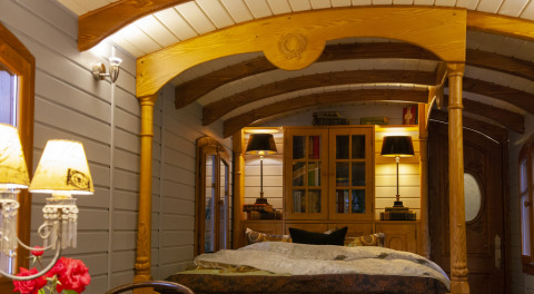 Hébergement glamping douillet avec intérieur en bois, lit double et éclairage chaud au Park am See, Autriche.