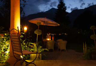 Hébergement glamping Park am See à Obertraun, Autriche, terrasse éclairée et ambiance chaleureuse du soir.