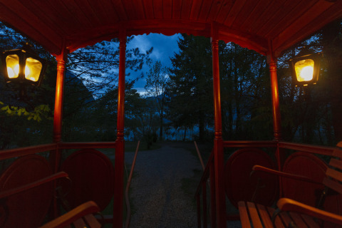Vista da una roulotte illuminata glamping al Park am See, Obertraun, Austria, al tramonto nel bosco.
