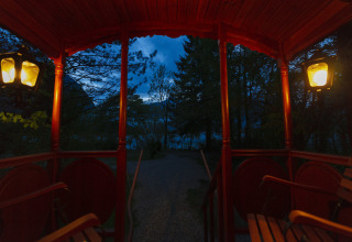 Vista desde una carreta iluminada de glamping en Park am See, Obertraun, Austria, al anochecer.
