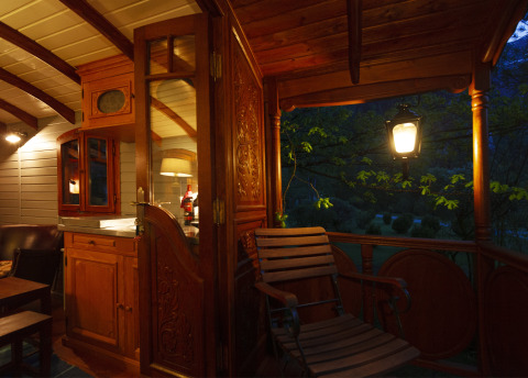 Alojamiento glamping acogedor con muebles de madera y veranda iluminada por la noche en Obertraun, Austria.