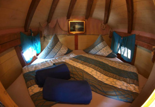 Interno accogliente di una casa sull'albero glamping a Het Culturele Eiland Einsiedler - Boomhutten in Sassonia.