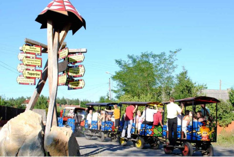 Des familles profitent d’un petit train coloré à Het Culturele Eiland Einsiedler - Cabanes dans les arbres, Saxe.