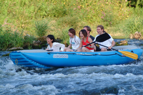 Un groupe de personnes fait du rafting sur une rivière en canot bleu proche du Het Culturele Eiland Einsiedler.