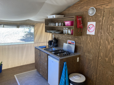 Volledige keuken in safaritent bij Glamping Chave Grande met kookvuur, koelkast en keukengerei.