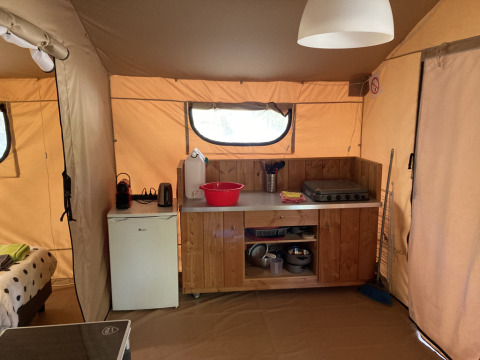 Gezellig interieur bij Glamping Chave Grande Safaritenten met keukentje, koelkast en fornuis.